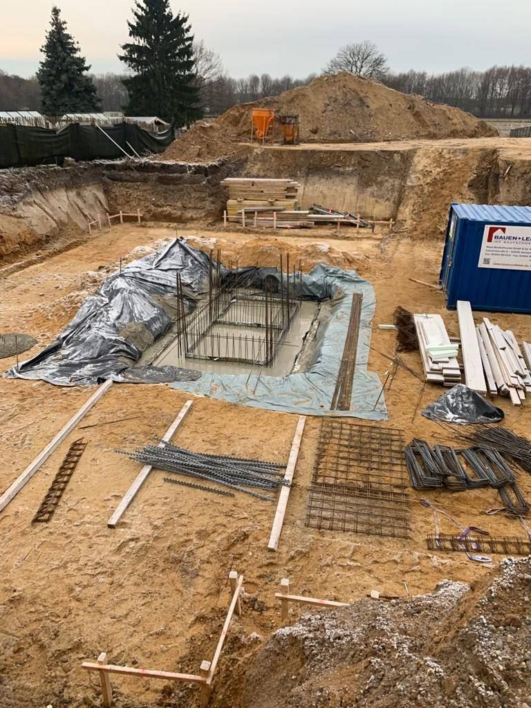 Ausgehobener Fundamentgraben mit eingelegter Bewehrung auf einer Baustelle