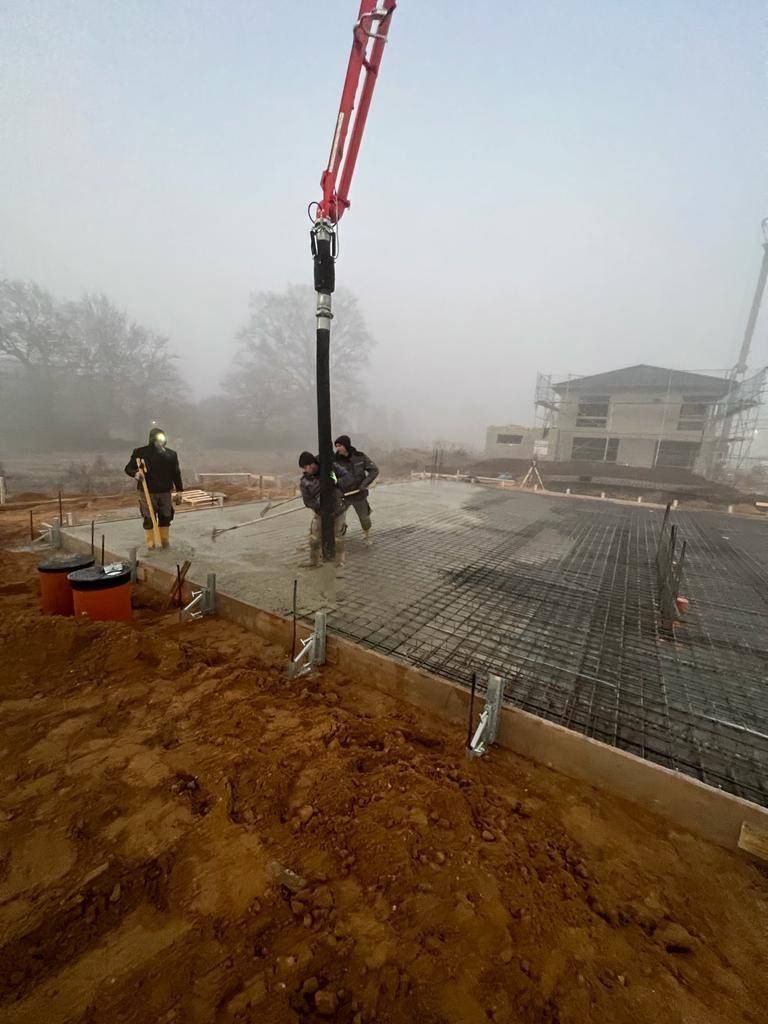 Baugerät im Einsatz auf einem vorbereiteten Baufeld bei Nebel